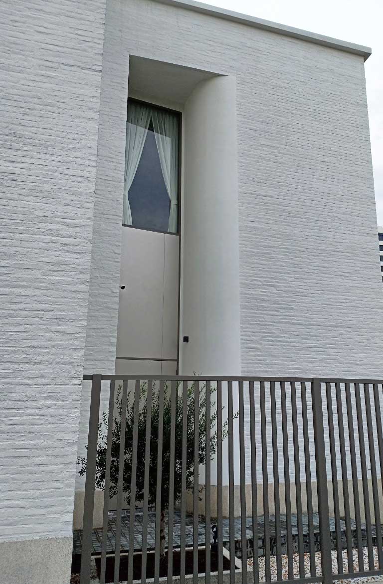 外牆白色文化石磁磚，圓弧面使用ADD STONE仿石漆塗抹出白色花崗岩
