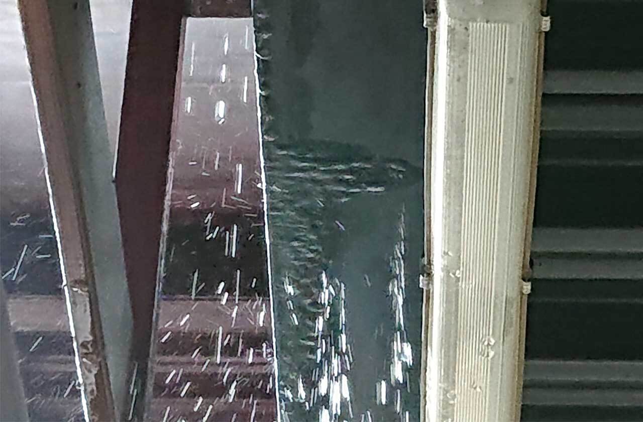 น้ำฝนไหลและกระเซ็นลงมาจากหลังคา