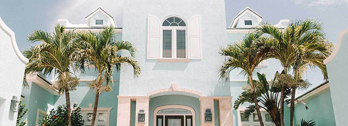 La pared exterior de la villa pulveriza el revestimiento de piedra falsa con gravillas. El color rosa con azul celeste, expresa la impresión tropical y viva.