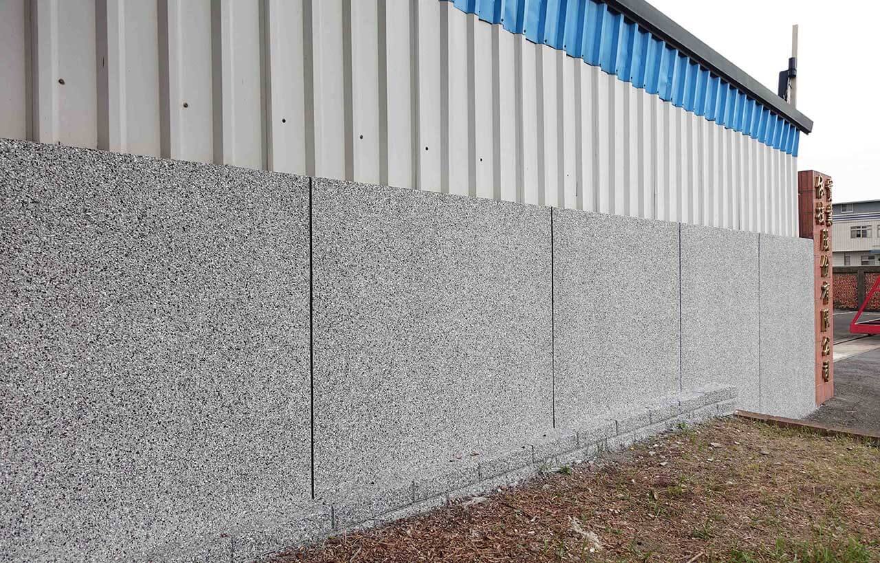 表面抿石子工法的圍牆噴塗覆蓋仿石漆，看起來像是整片天然花崗石岩板