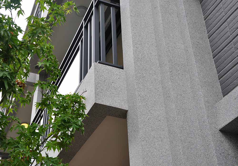 台灣桃園透天別墅使用多種建材融合，創造沈穩寧靜卻又表情豐富的建築外觀，黑色的磁磚、鐵欄杆與深灰色的ADD STONE亞仿石漆