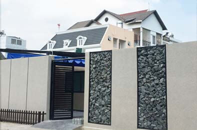 越南胡志明市住家圍牆創意的仿石漆應用，石頭與花崗岩牆面色彩互相輝映