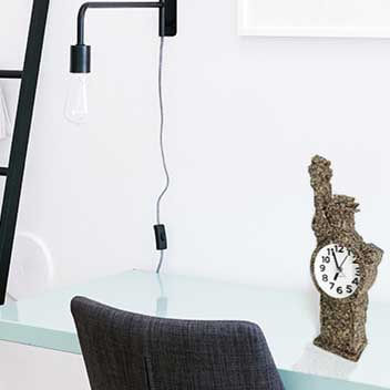 A small stone-carved clock is placed on the desk to highlight personal artistic style
