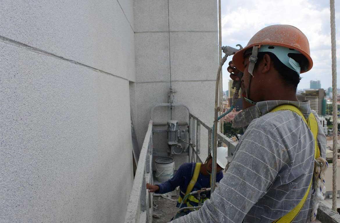 施工中的柬埔寨 D.I.Riviera 麗薇雅酒店，工人正在飯店外牆噴塗ADD STONE亞崗仿石漆